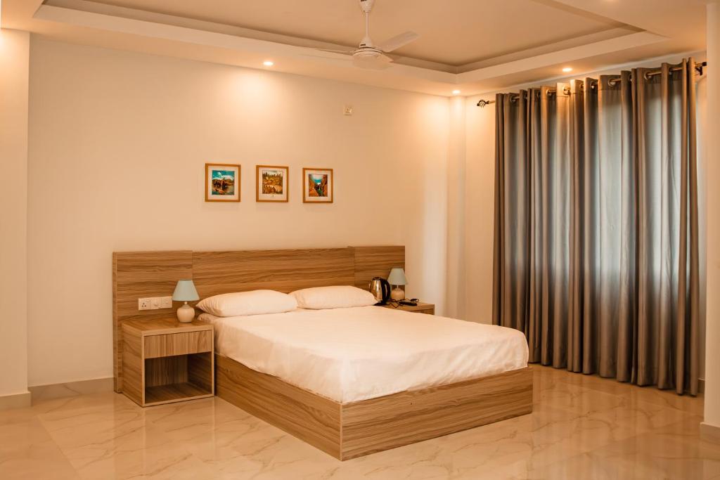 a bedroom with a large bed with a wooden headboard at ANILAD Kandy in Kandy