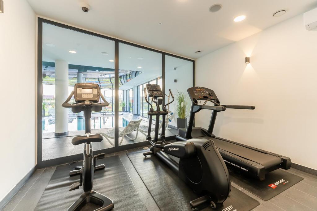 a gym with two treadmills and two exercise bikes at Apartament Westin House 303 in Kołobrzeg