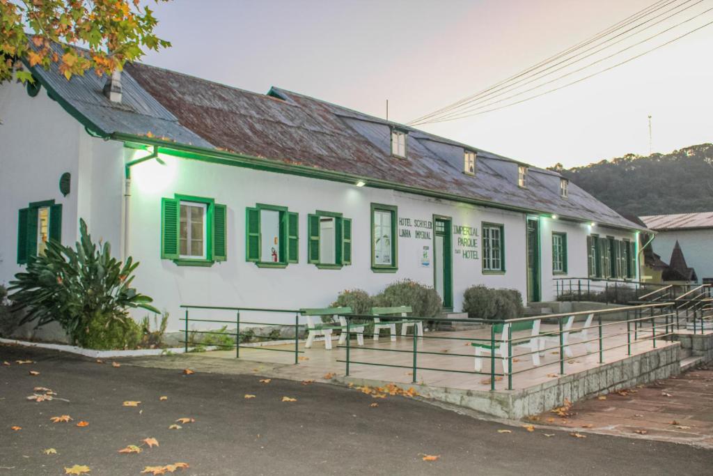 un edificio blanco con persianas verdes en una calle en Hotel Parque en Nova Petrópolis