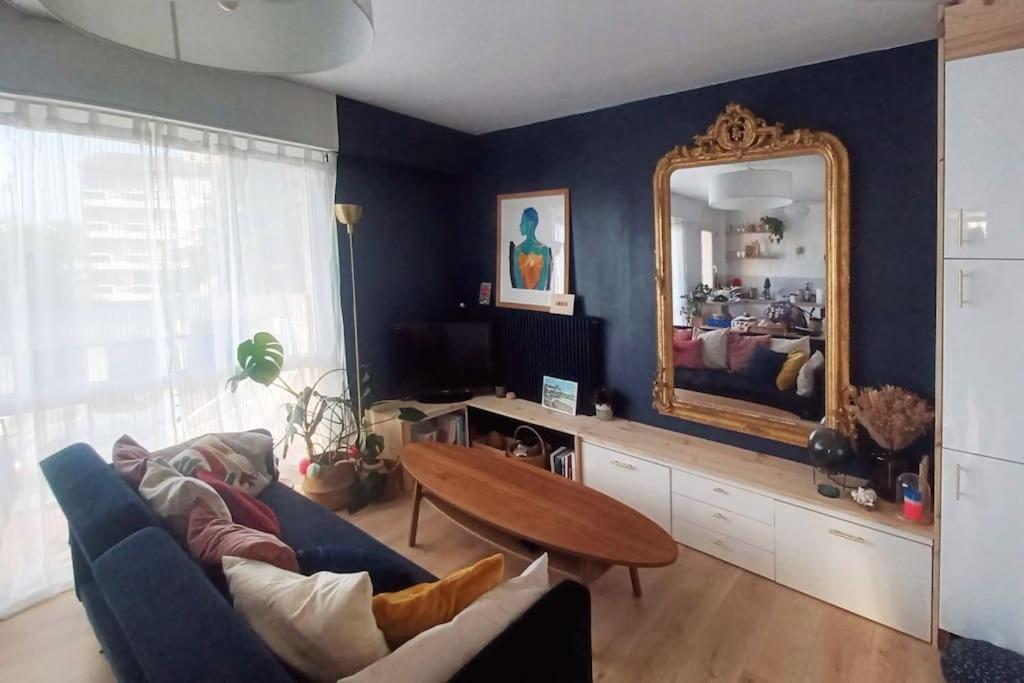 ein Wohnzimmer mit einem Sofa und einem Spiegel in der Unterkunft Magnifique T2 à Bordeaux in Bordeaux