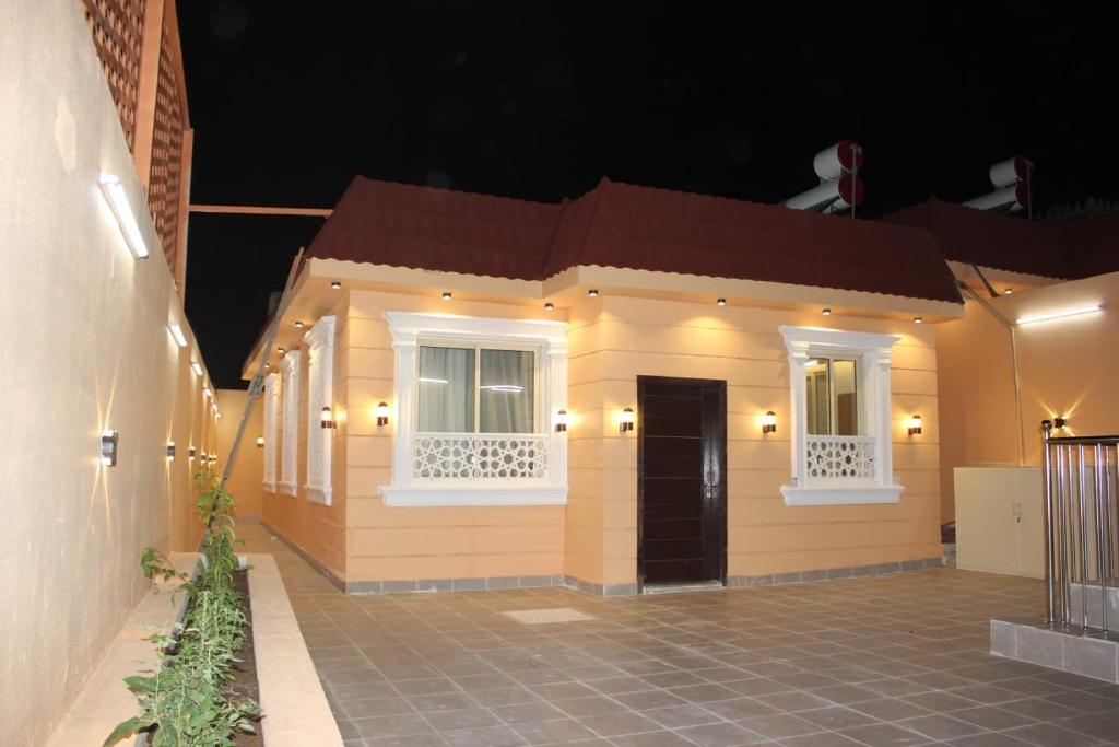 - une petite maison avec une porte et des fenêtres la nuit dans l'établissement شاليهات التميز الراقي, à Al Hada