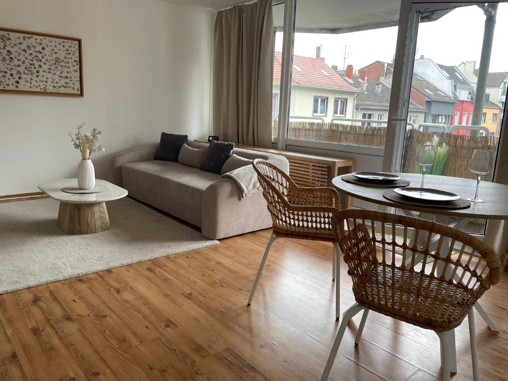 ein Wohnzimmer mit einem Sofa, einem Tisch und Stühlen in der Unterkunft Ferienwohnung mit 2 Zimmer im Belgischen Viertel in Köln