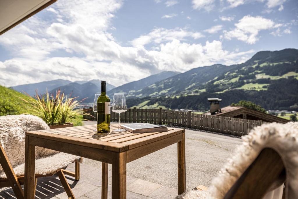 a bottle of wine sitting on a wooden table on a patio at VIEW4TWO / Chalet-Apartment Zillertal in Hart im Zillertal
