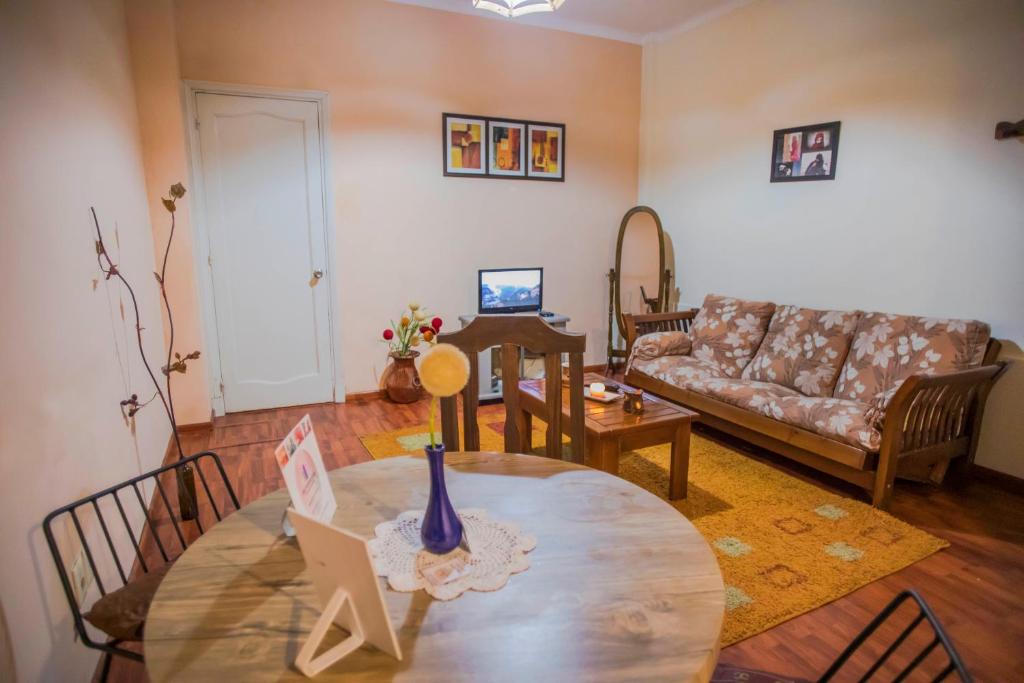 uma sala de estar com uma mesa e um sofá em Apartamento único en el corazón de Montevideo em Montevidéu