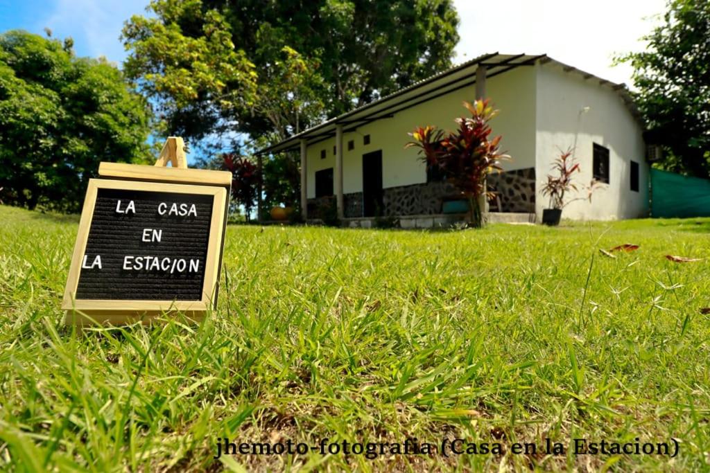 a sign in the grass in front of a house at casa en la estación cocornà in Puerto Triunfo