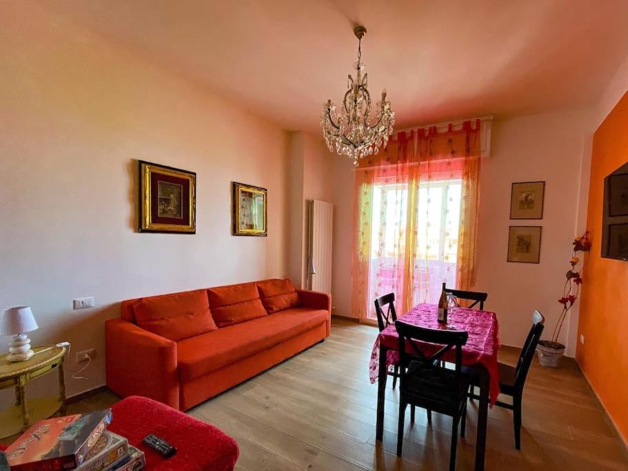a living room with a red couch and a table at Appartamento vacanze Rotonda Sunrise in Senigallia