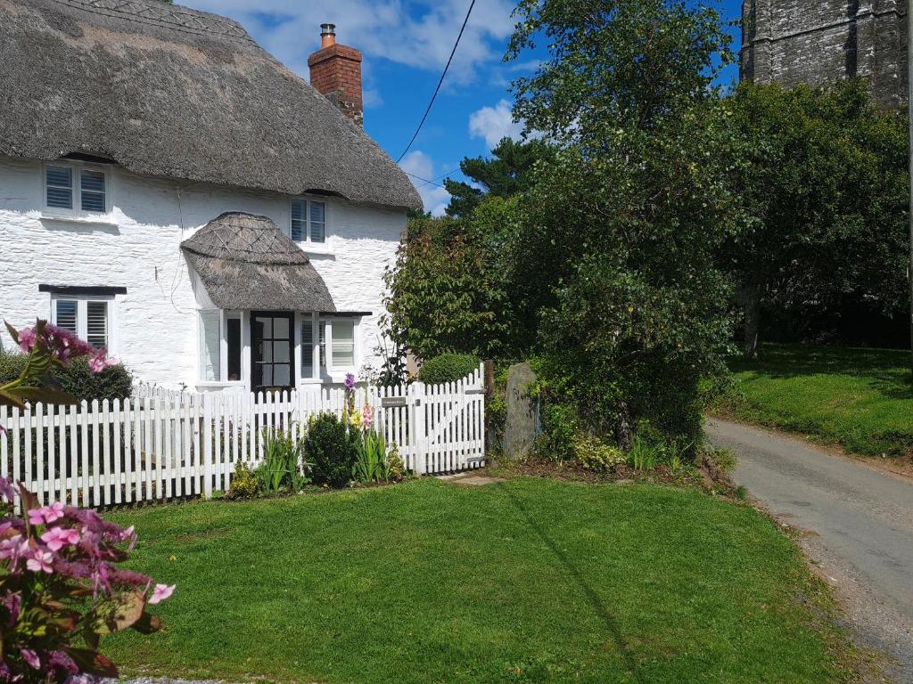 a white cottage with a white picket fence at Furneaux Hatch in Kingsbridge