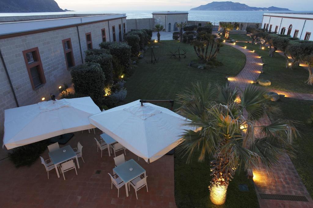 an overhead view of a patio with tables and umbrellas at I Pretti Resort in Favignana