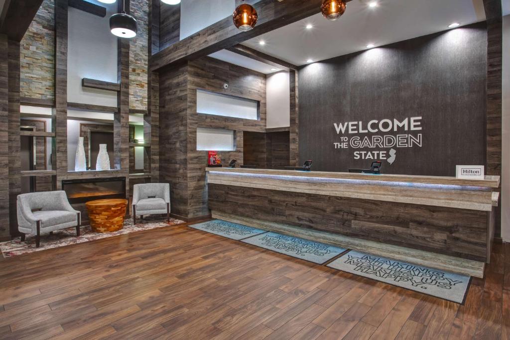 een lobby met een welkomstbord op de muur bij Hampton Inn & Suites By Hilton- Newark Airport Elizabeth in Newark