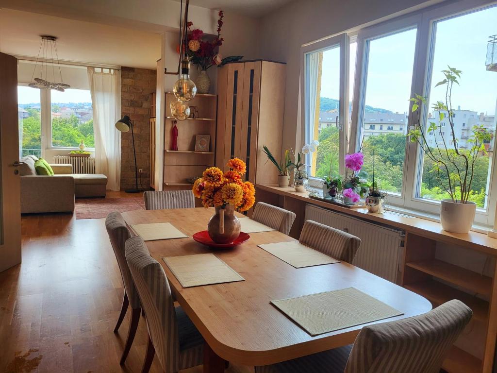 a dining room table with a vase of flowers on it at Sunny Panorama Flat near Castle with balcony in Budapest