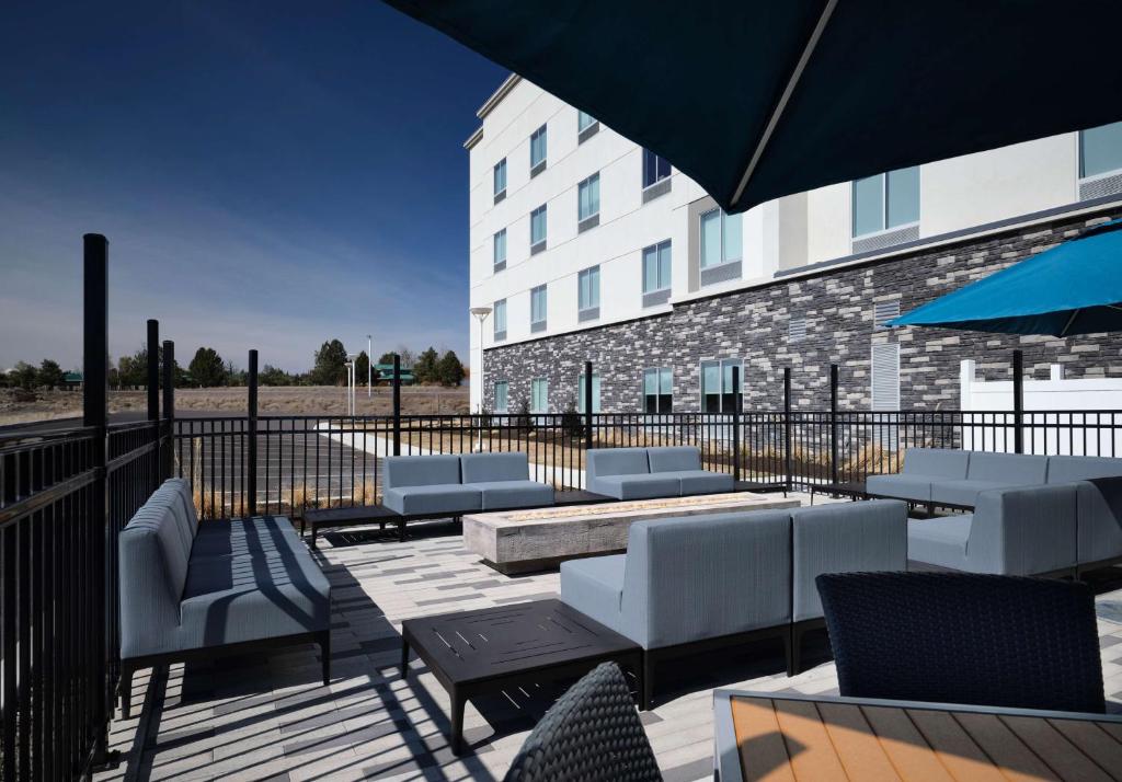a patio with chairs and tables and a building at Hampton Inn Redmond Bend Airport in Redmond