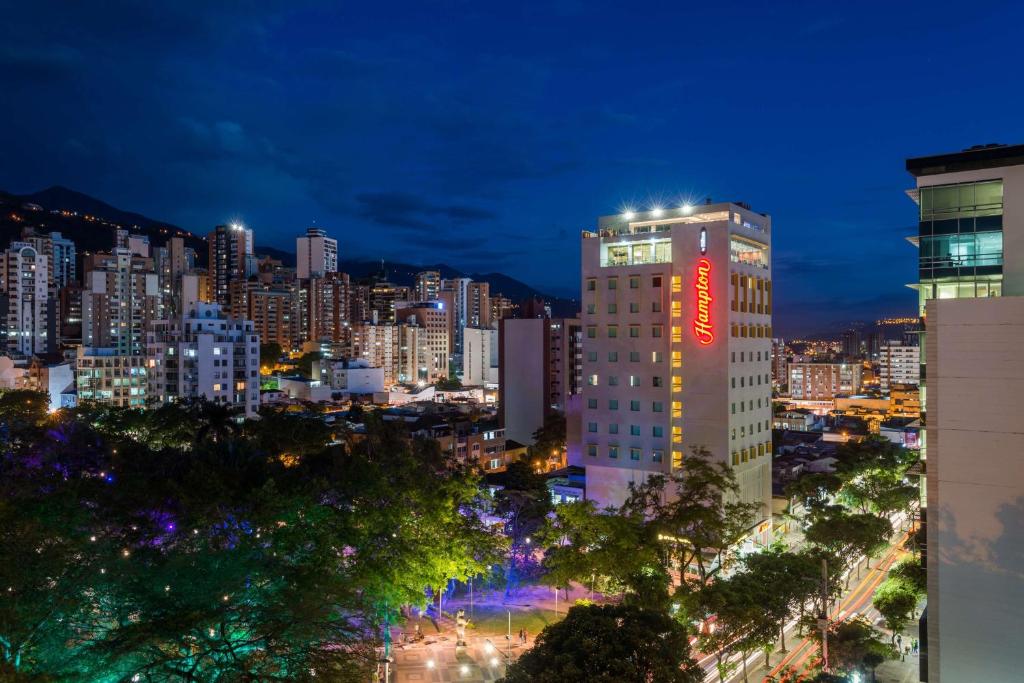 wysoki budynek z znakiem na boku w obiekcie Hampton By Hilton Bucaramanga w mieście Bucaramanga
