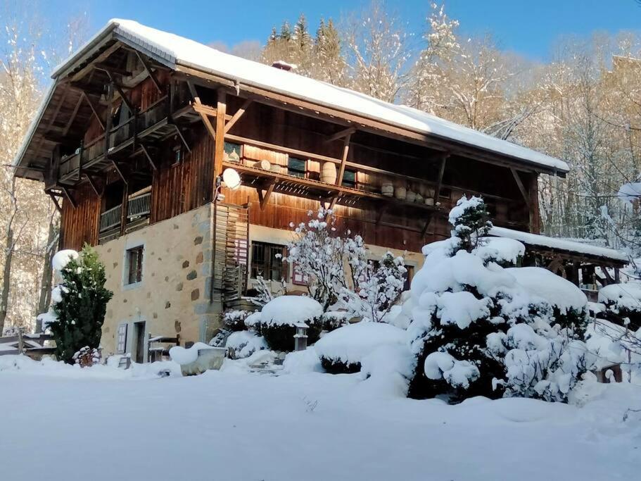 a log cabin in the snow with snow covered trees at Chalet de Creytoral in Arâches-la-Frasse