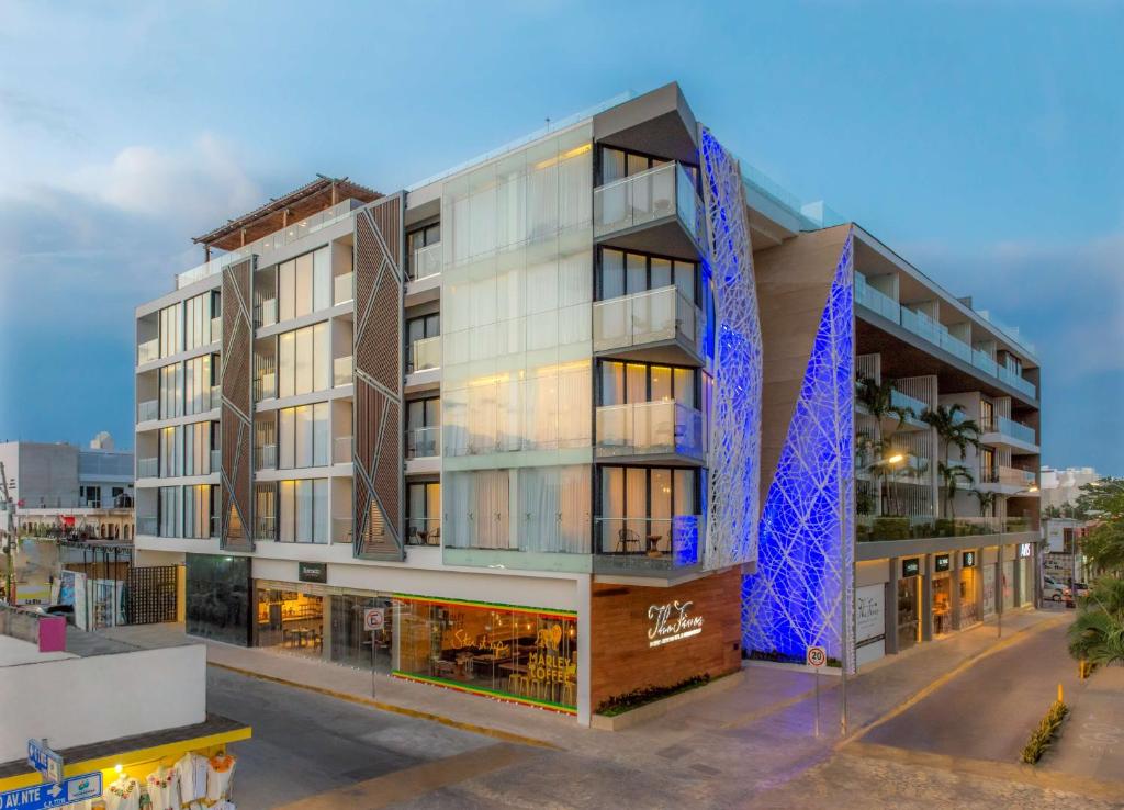 un edificio de oficinas con una fachada azul en The Fives Downtown Hotel & Residences, Curio Collection by Hilton en Playa del Carmen