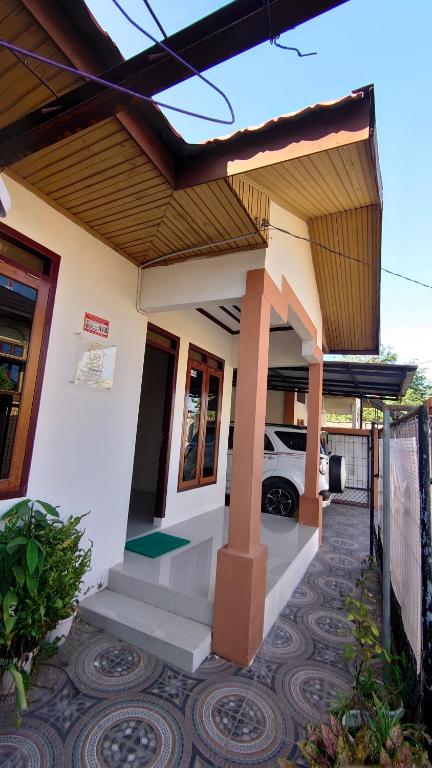 a house with a car parked in the driveway at Mawar Homestay in Banda Aceh