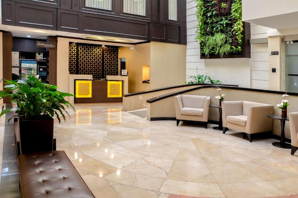 a lobby of a hotel with chairs and plants at Hilton Garden Inn Guatemala City in Guatemala