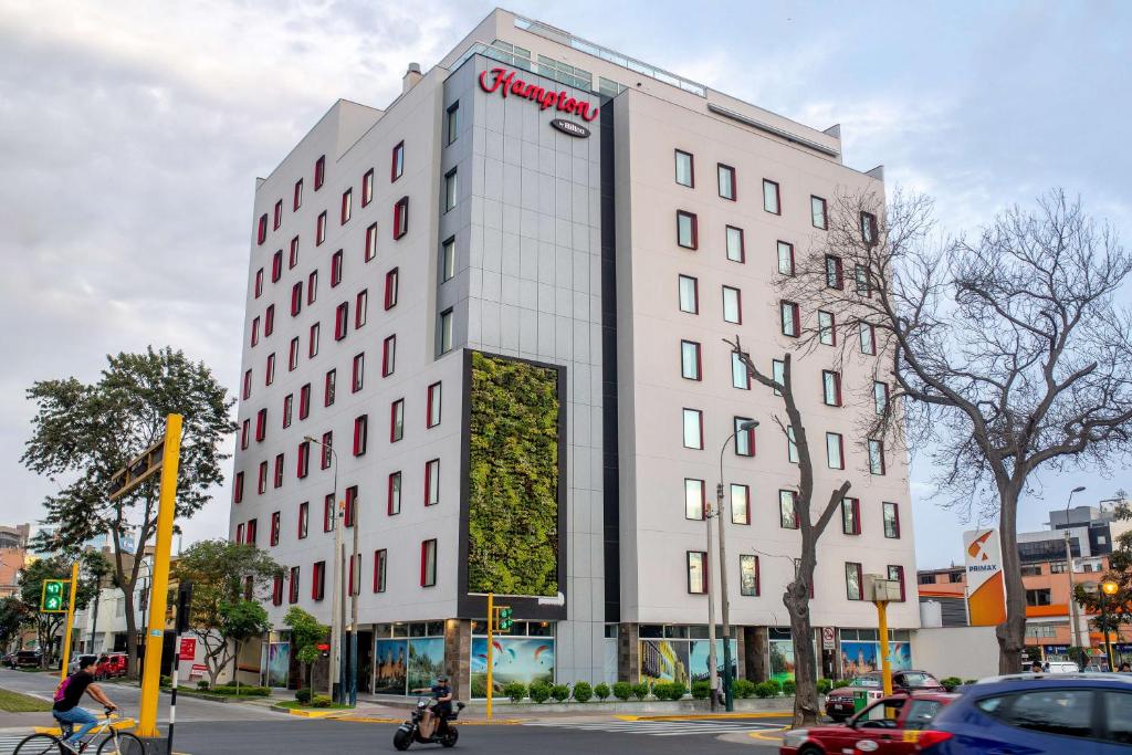 un edificio blanco con un cartel en el costado en Hampton By Hilton Lima San Isidro en Lima