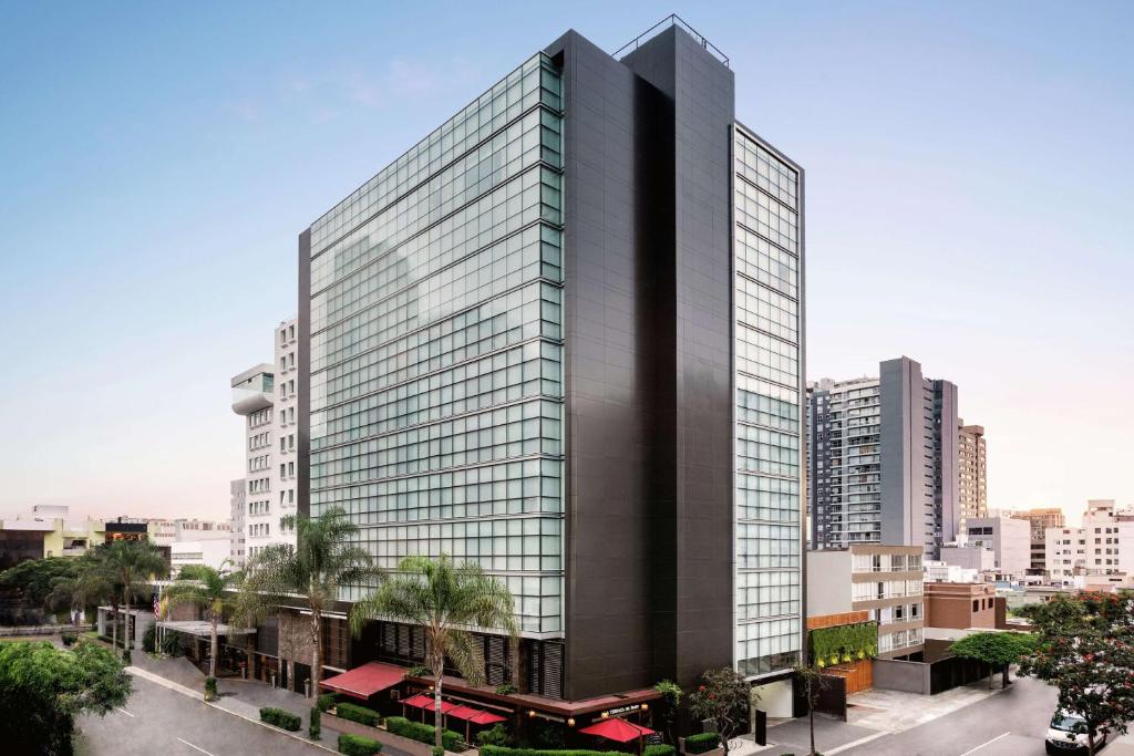 ein hohes Gebäude mit Glasfenstern in einer Stadt in der Unterkunft DoubleTree by Hilton Lima Miraflores El Pardo in Lima