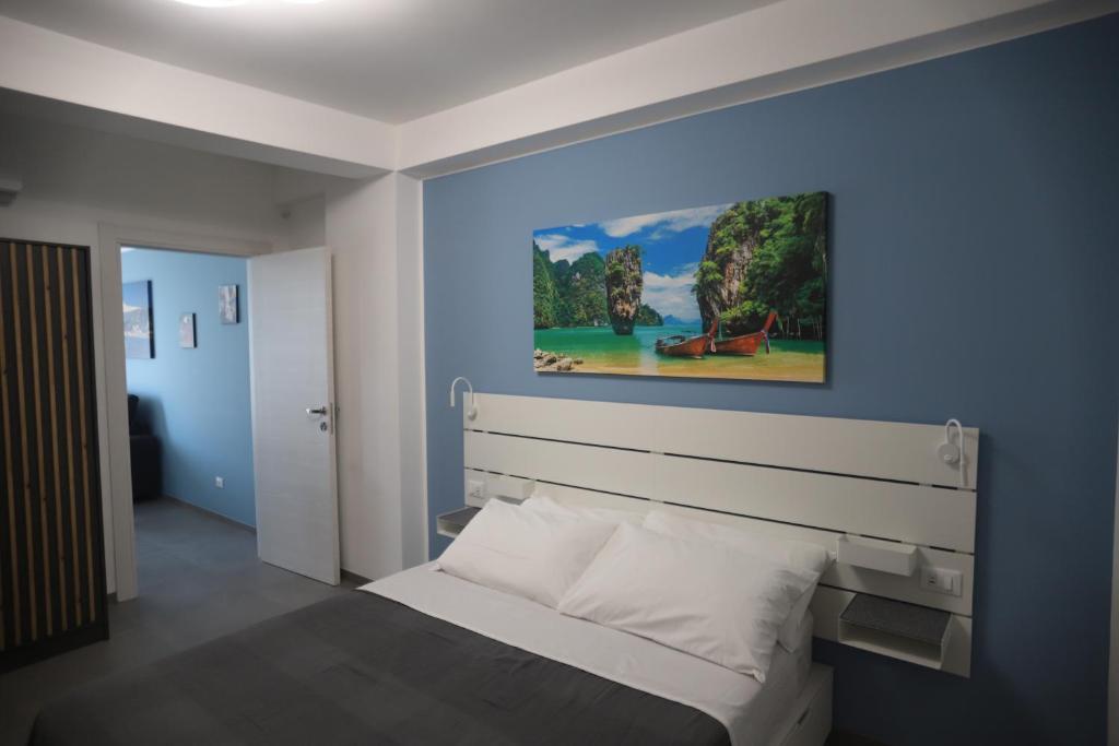 ein Schlafzimmer mit einem Bett und einem Wandgemälde in der Unterkunft Casa Vacanza Da Angela & Corrado in Pozzallo
