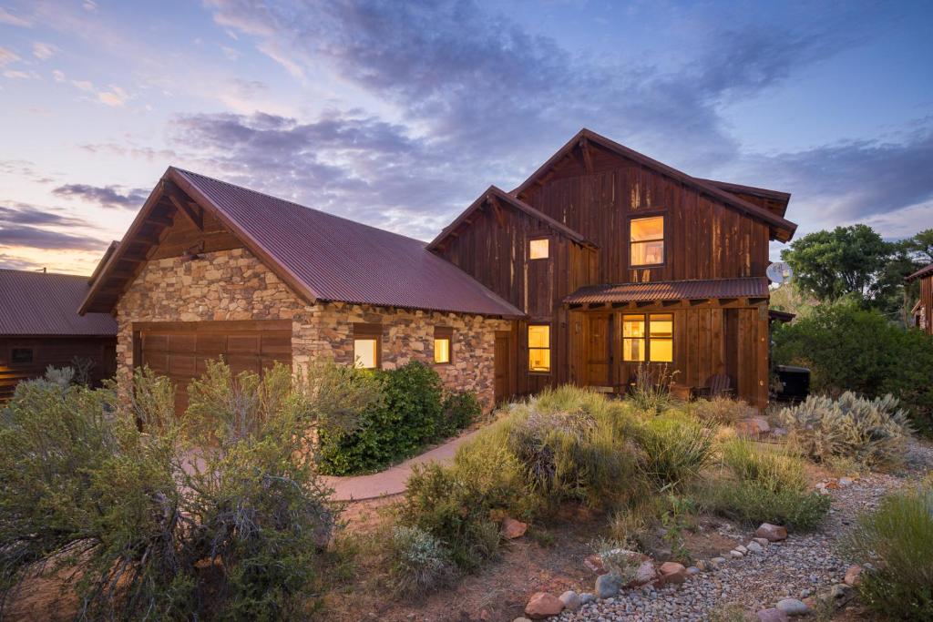 een groot houten huis met een steen bij Coyote Run #2 - Stunning Views in Moab