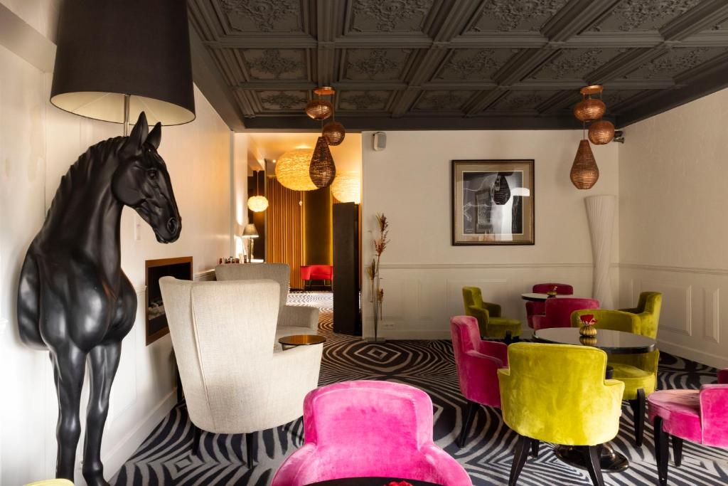 een lobby met een standbeeld van een paard in het midden van een kamer bij Hostellerie de la Renaissance - Teritoria in Argentan
