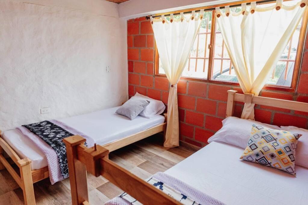 a room with two beds and a window at Cabaña vacacional en San Gil 'El Mirador' in San Gil