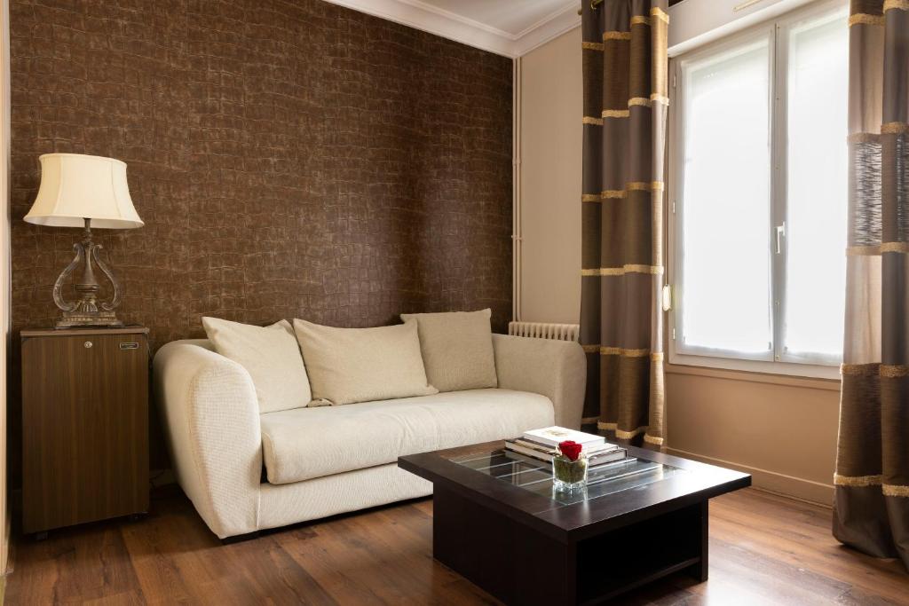 a living room with a couch and a coffee table at Hostellerie de la Renaissance - Teritoria in Argentan