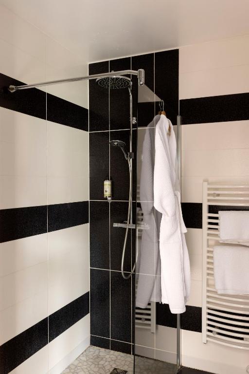 a bathroom with a shower with black and white stripes at Hostellerie de la Renaissance - Teritoria in Argentan
