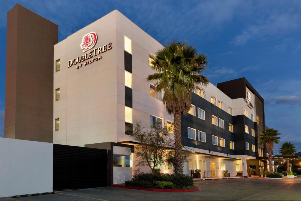 un edificio de hotel con una palmera delante en DoubleTree by Hilton Queretaro en Querétaro