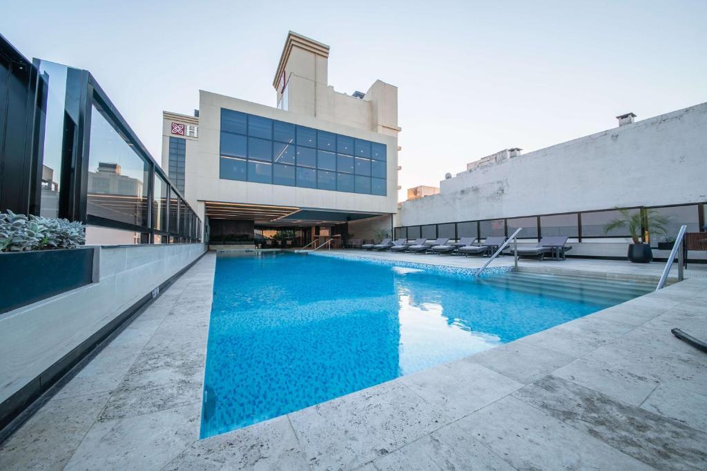 una grande piscina di fronte a un edificio di Hilton Garden Inn Santiago Del Estero - 4 Estrellas a Santiago del Estero