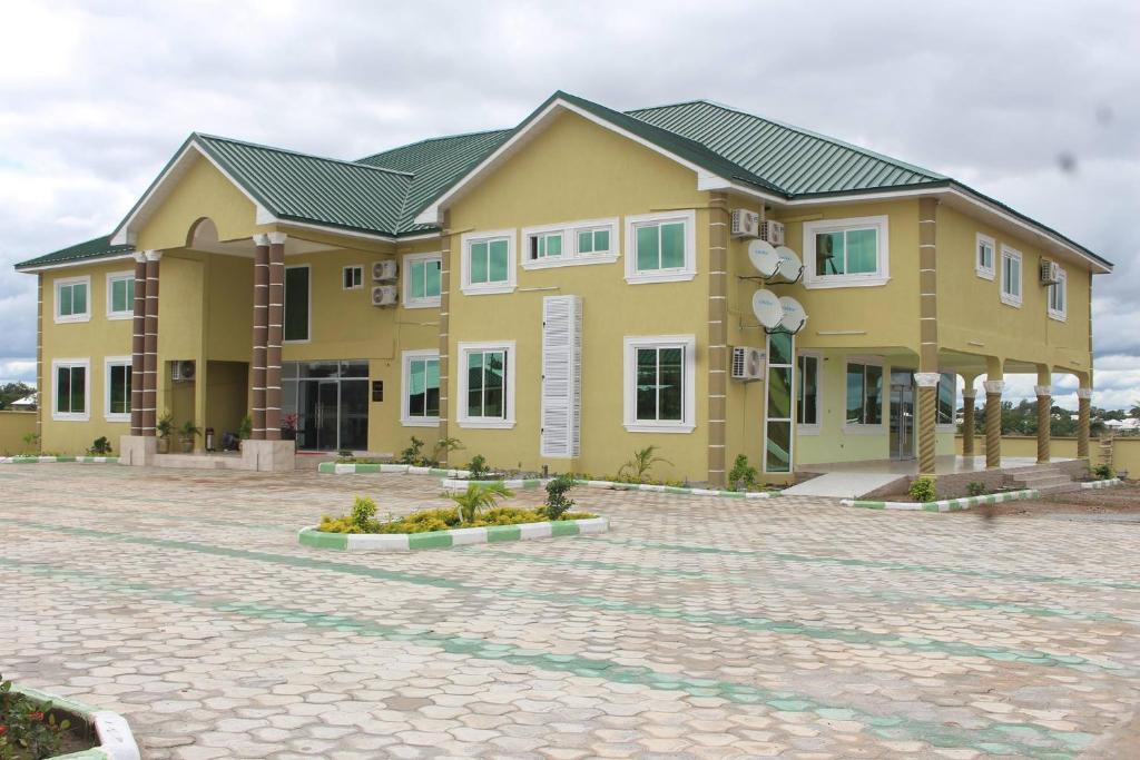 a large yellow building on a brick road at Dellagio Hotel in Wa