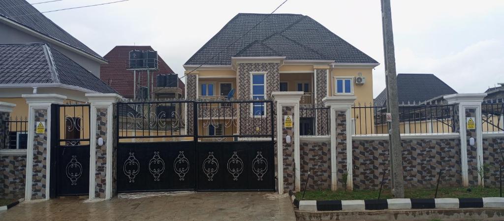 uma fila de casas com um portão preto em De-Convenant Apartment em Abuja