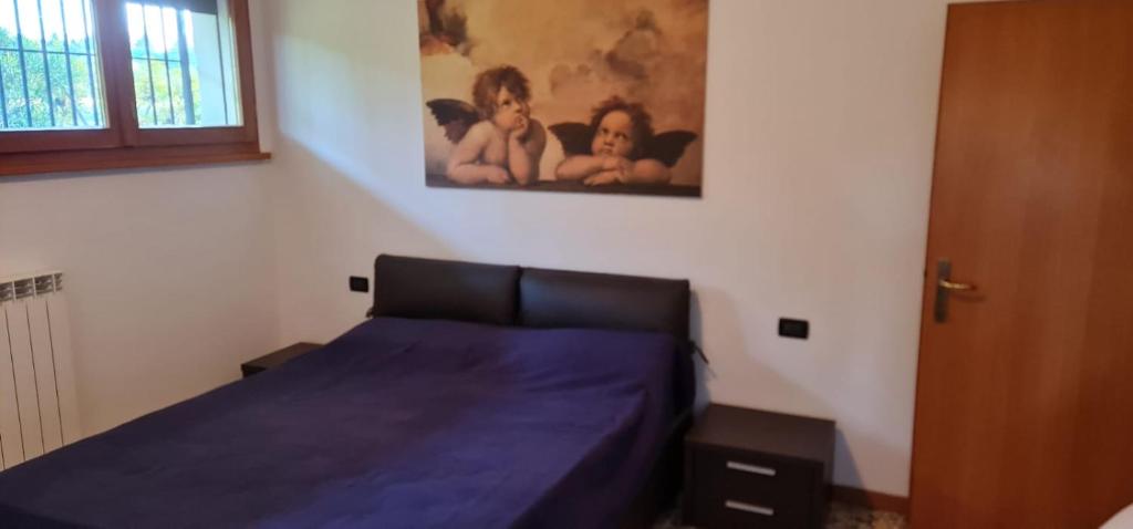 um quarto com uma cama com lençóis azuis e um quadro em Casa Nostra em Imola