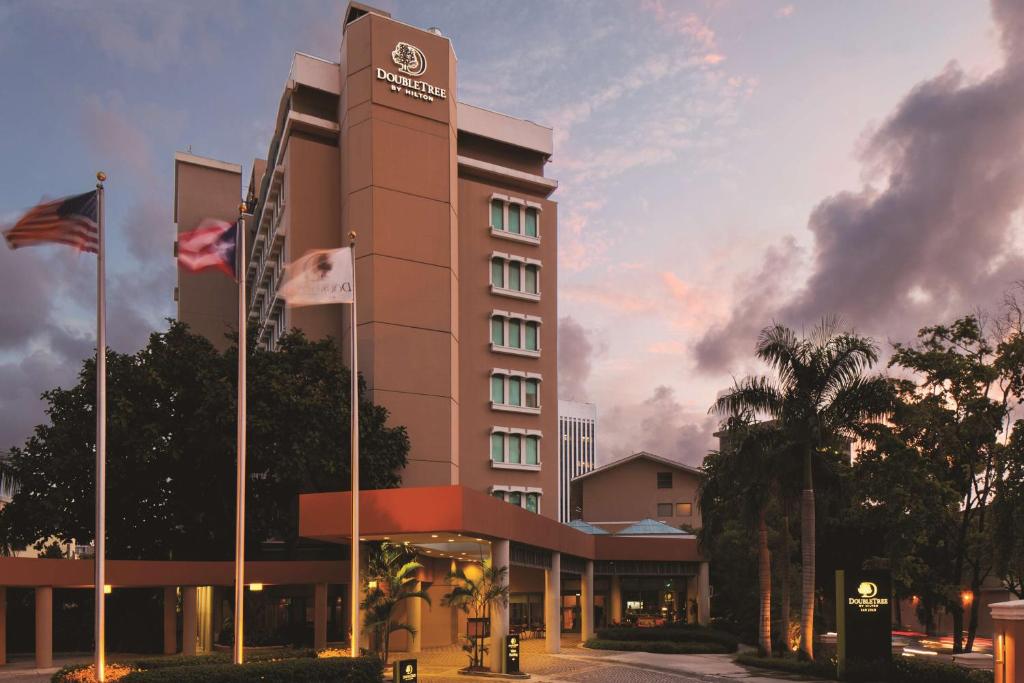 un rendimiento de un edificio de hotel con bandera en DoubleTree by Hilton San Juan, en San Juan