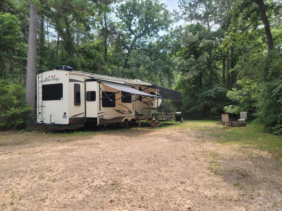 una caravana estacionada en un campo en el bosque en Walnut Creek Retreat, en Waller