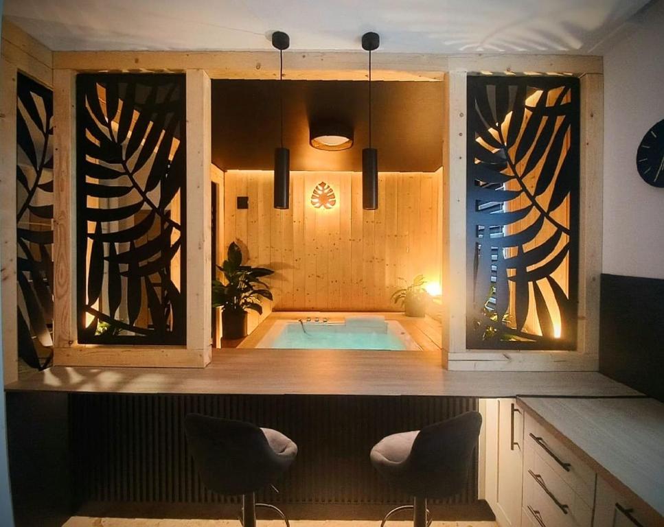 a jacuzzi tub in a room with two chairs at VIP APARTAMENT MALMEDA JACUZZi in Białystok