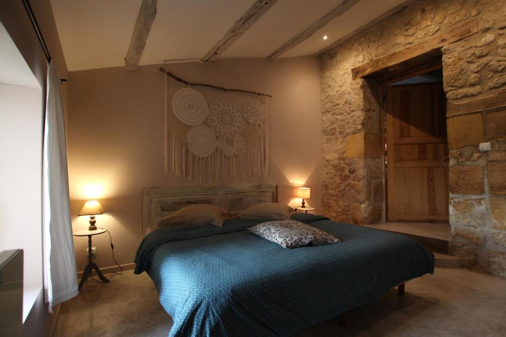 1 dormitorio con 1 cama con sábanas azules y 2 lámparas en La Grange des Anges, en Blanc