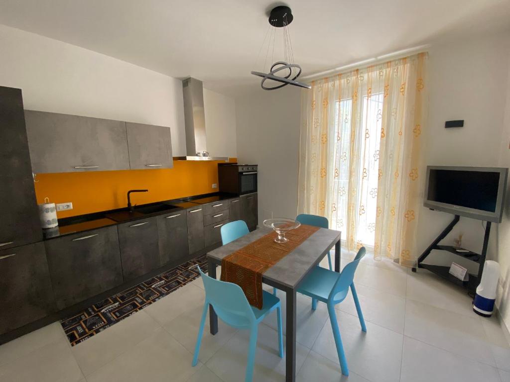 a kitchen with a dining table and blue chairs at AleVale apartment 450mt mare in Grottammare