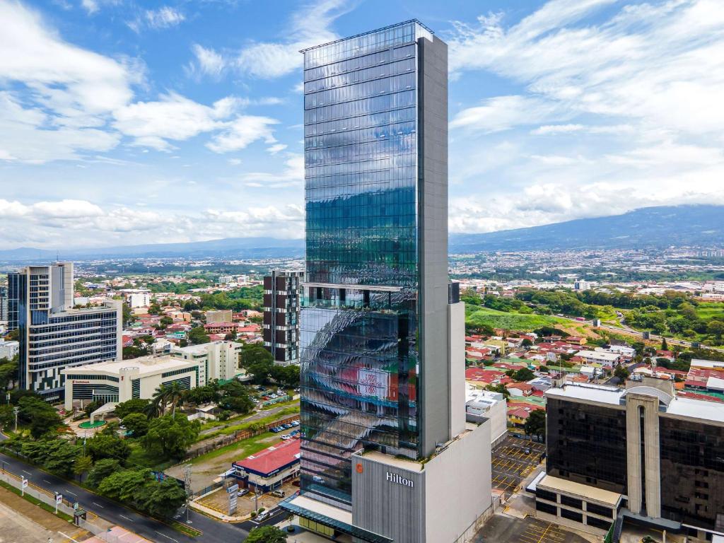 a tall skyscraper in the middle of a city at Hilton San Jose La Sabana in San José