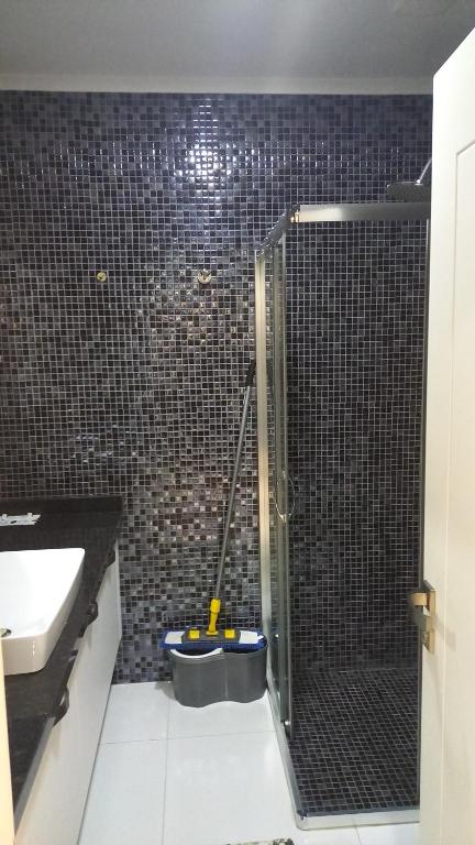 a bathroom with a shower with a mop in it at Eco Marine Residance in Kargicak