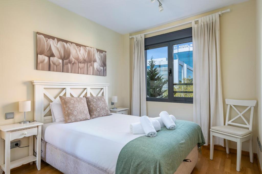 a bedroom with a white bed and a window at Charming Nuevo Madrid in Madrid