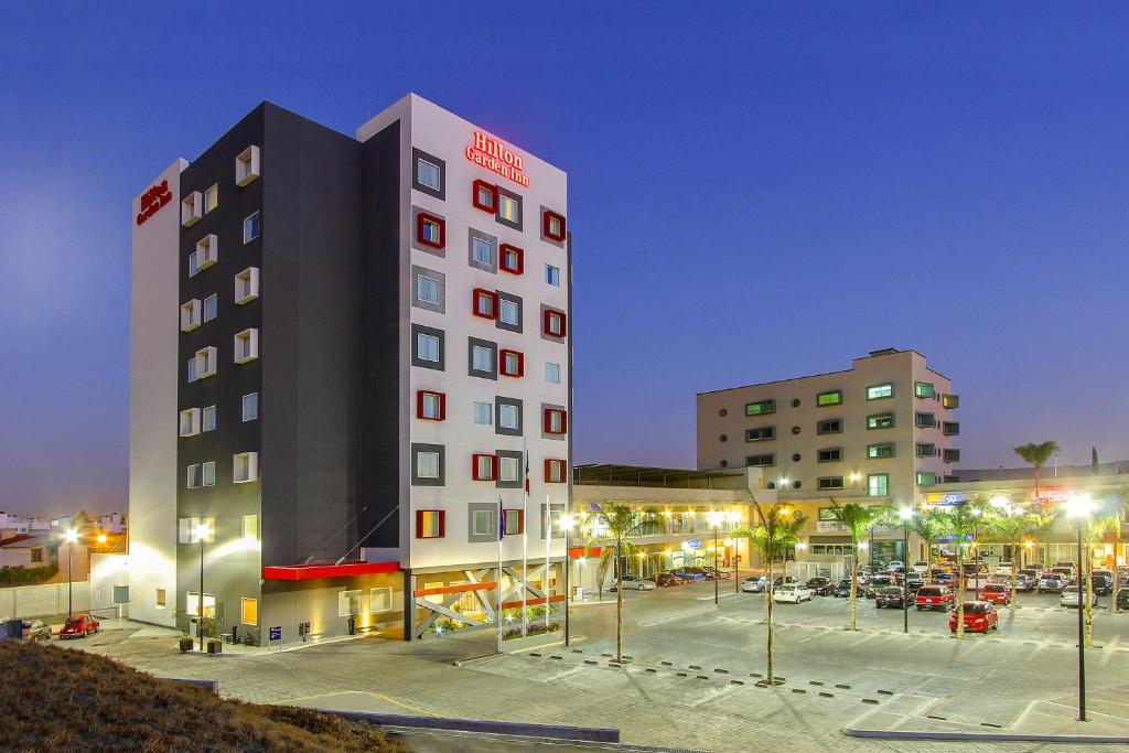 um edifício de hotel com um parque de estacionamento em frente em Hilton Garden Inn Queretaro em Querétaro