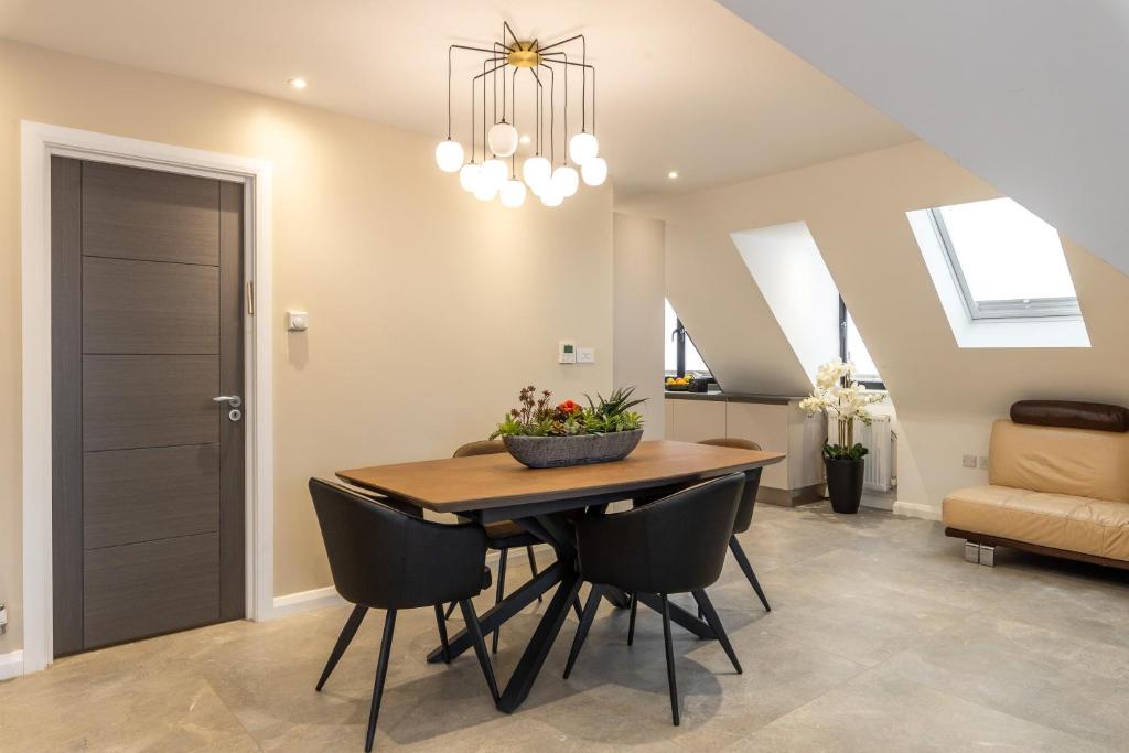 une salle à manger avec une table en bois et des chaises noires dans l'établissement Beautiful 2-Bed Apartment in London, à Londres