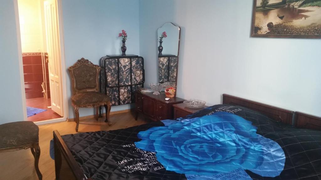a bedroom with a blue blanket on a bed at Hotel MMG in Tbilisi City