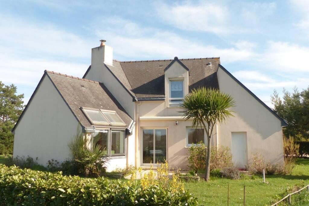 a white house with a palm tree in the yard at Ty Kerigan, Maison 3* proche de la plage - Locmariaquer in Locmariaquer