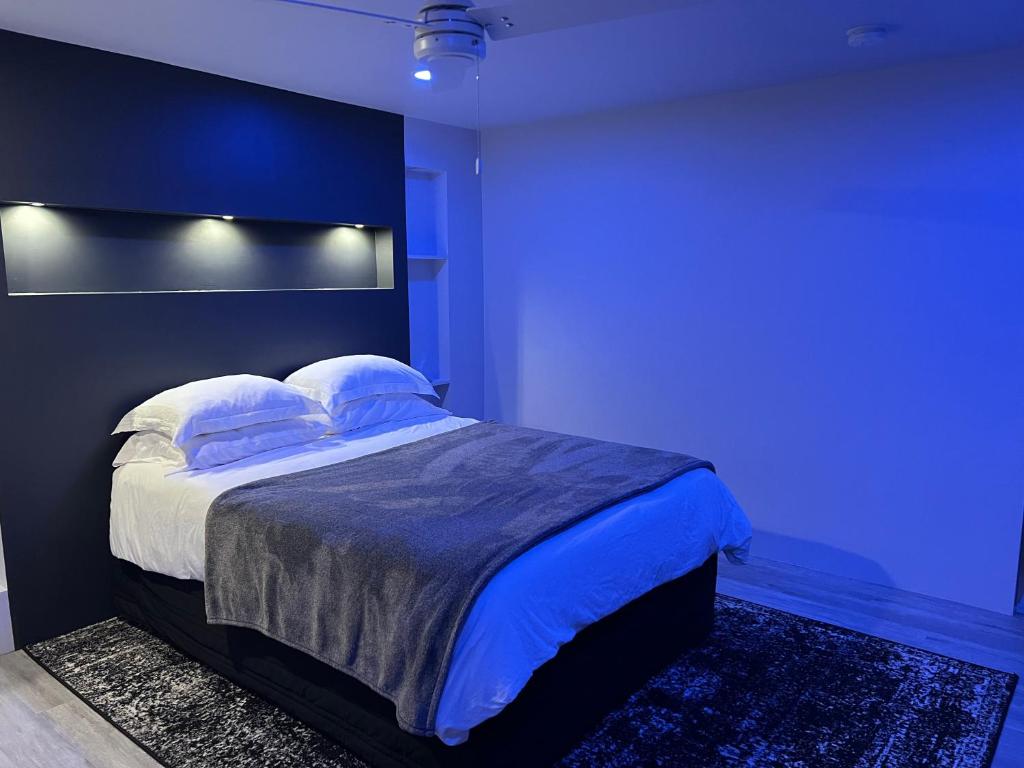 1 dormitorio azul con 1 cama grande con almohadas en Silva Domus, en West Orange