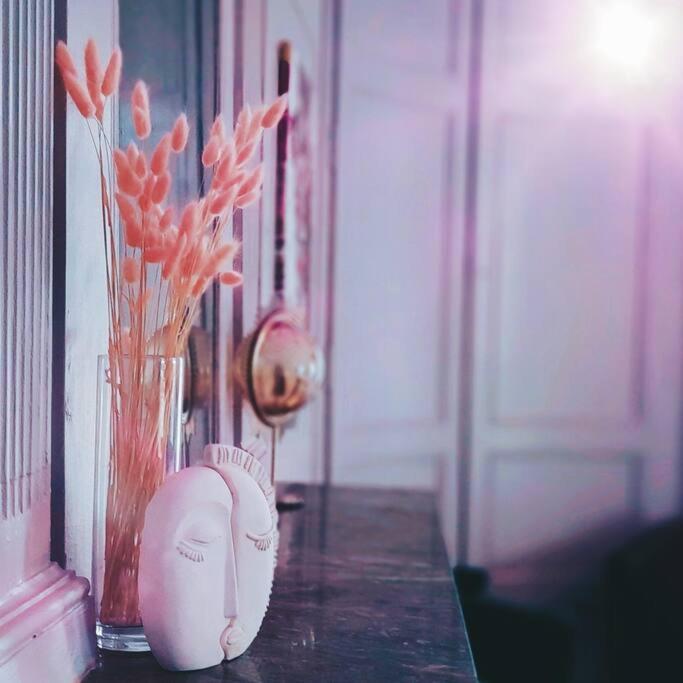 une table avec deux vases et un vase avec des fleurs orange dans l'établissement Suite Romantique La Charmante, à Villersexel