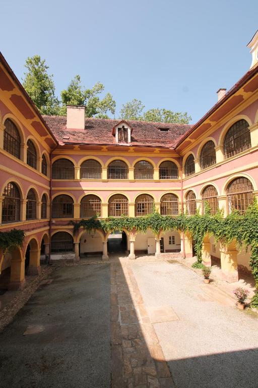 um grande edifício com um pátio com vinhas em Schloss Frauenthal em Deutschlandsberg