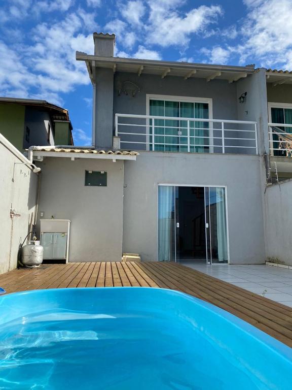 una casa con piscina frente a ella en Casa de Hóspedes com Piscina em Porto Belo, en Porto Belo