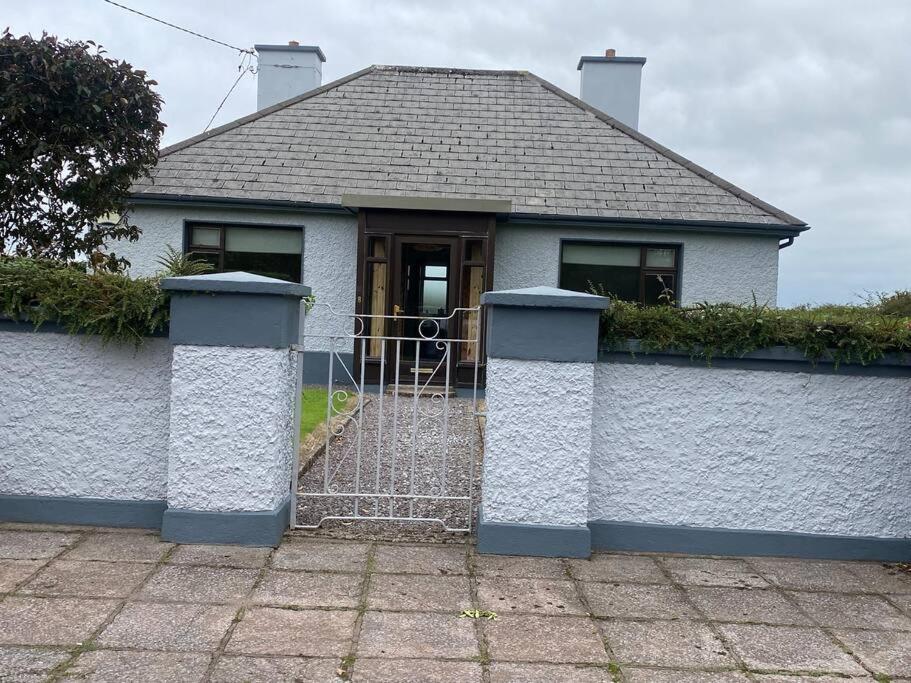 Uma casa branca com um portão à frente. em An Cnoc em Killorglin